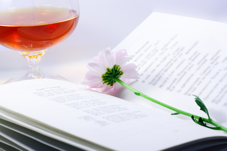 opened book with chrysanthemum and a glass of brandy